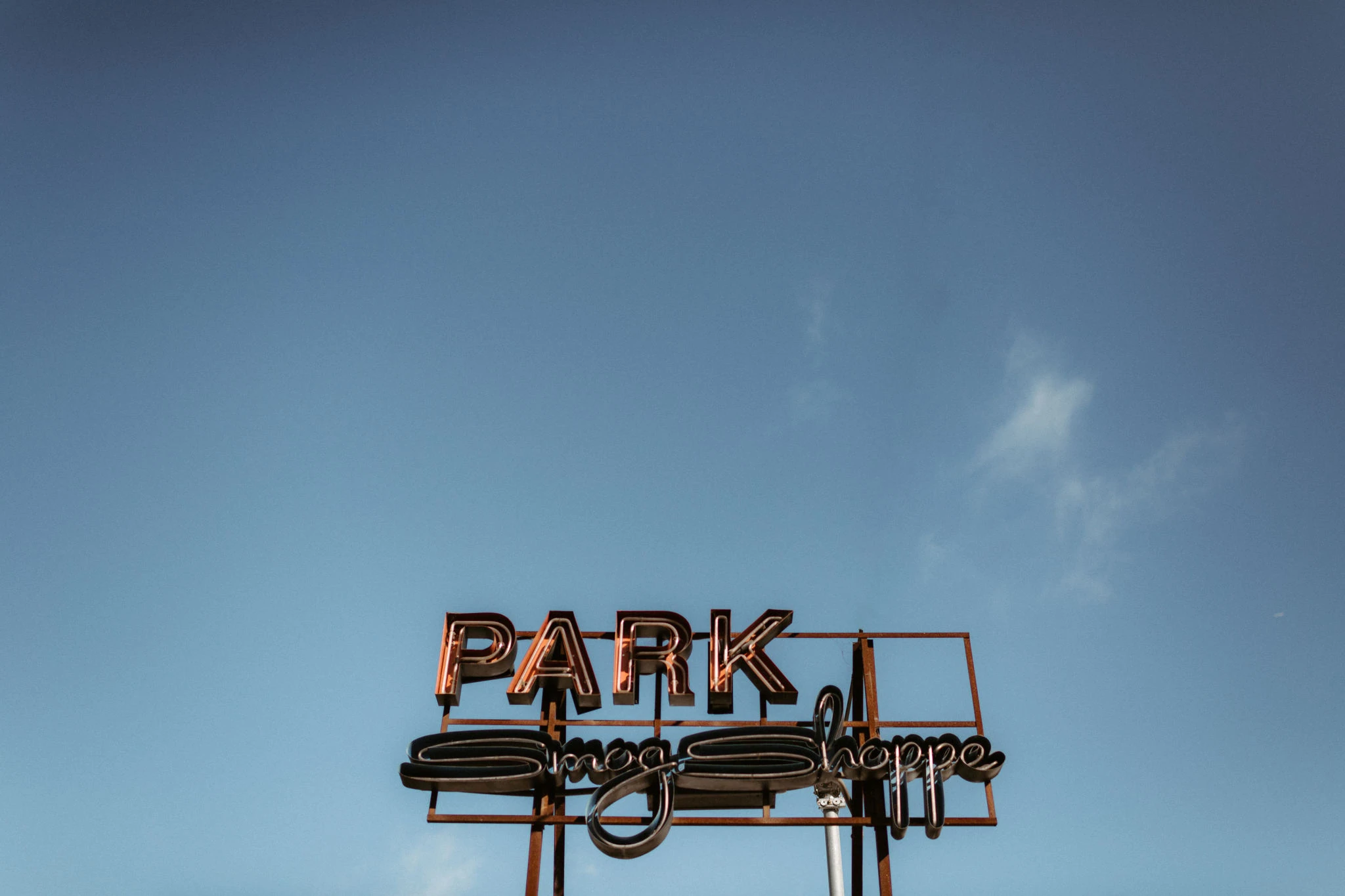 SmogShoppe’s vintage PARK sign against the blue sky