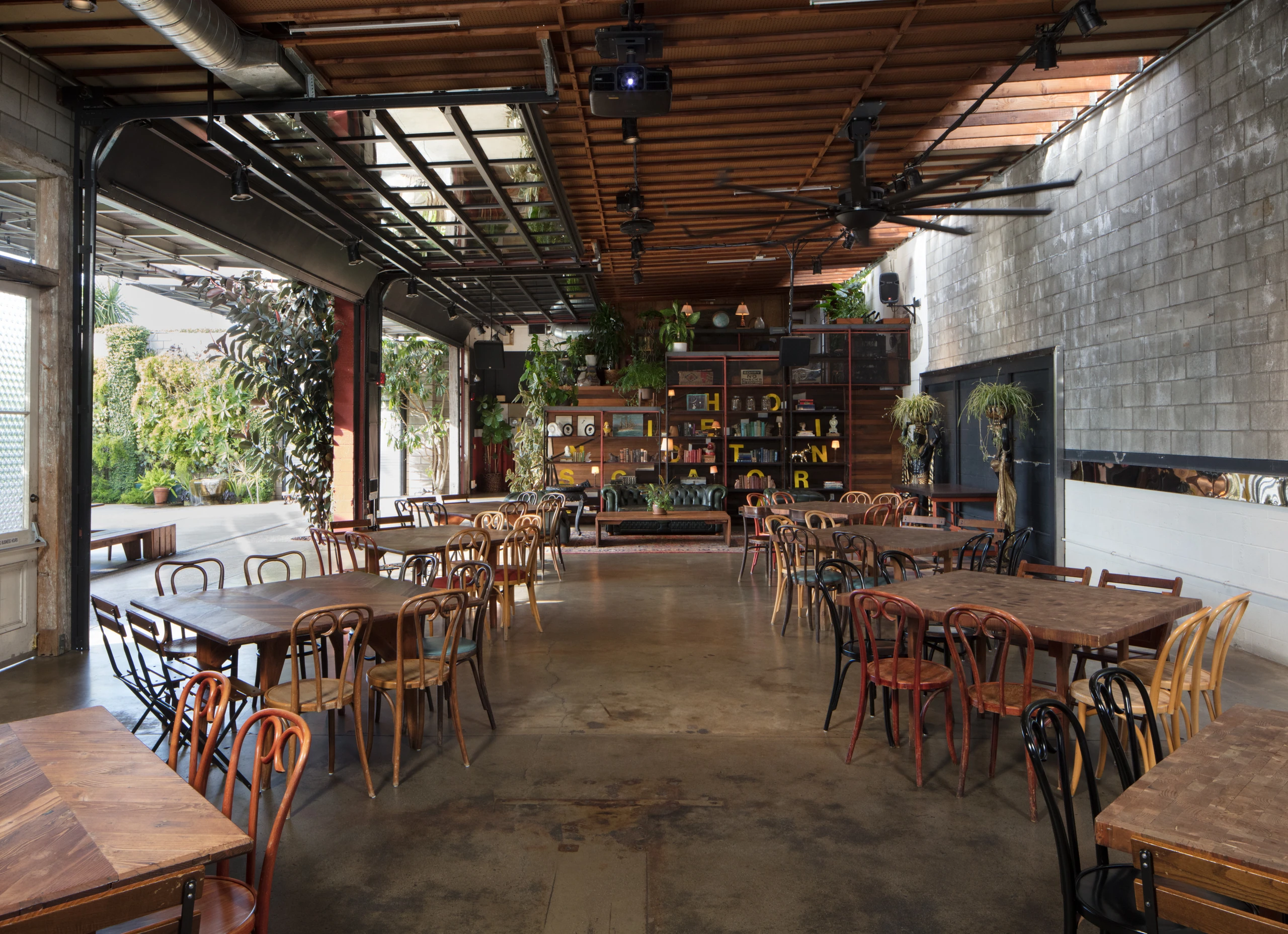Dining tables and reclaimed shelving in SmogShoppe’s Grand Hall